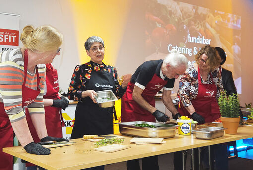 Menschen schneiden Gemüse für Salat