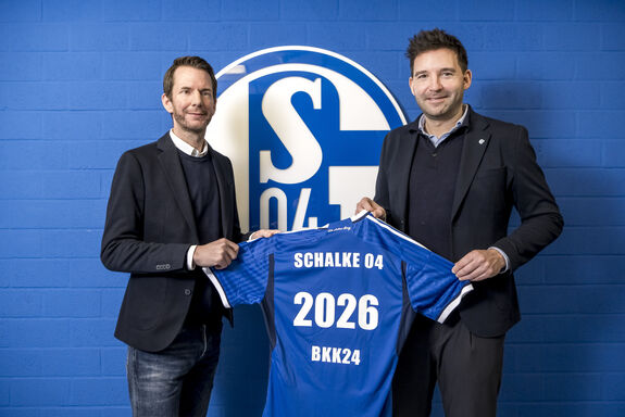 Vertreter von BKK24 und schalke 04 halten Trikot mit der Nummer 2026 in die Höhe