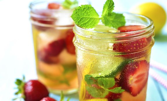 Auf einem Tisch stehen zwei Cocktails mit vielen Früchten darin.