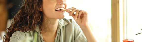 Eine Frau knabbert einen gesunden Cracker