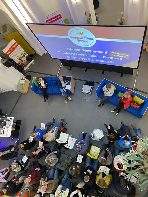 Vogelperspektive auf Zuschauende der Konferenz