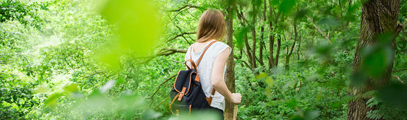 Frau spaziert durch Wald