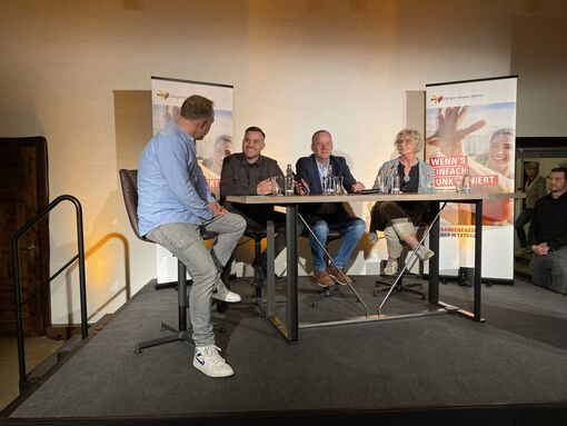 Menschen am Stehtisch auf Bühne