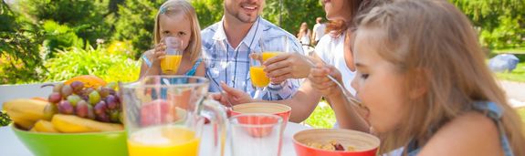 Eine Familie sitzt am Tisch mit einem vitaminreichen Frühstück 