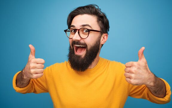 Ein Mann streckt freudig die Daumen hoch.