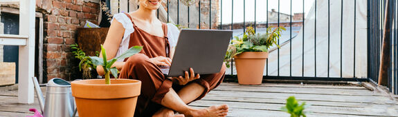 Frau gärtnert auf Balkon